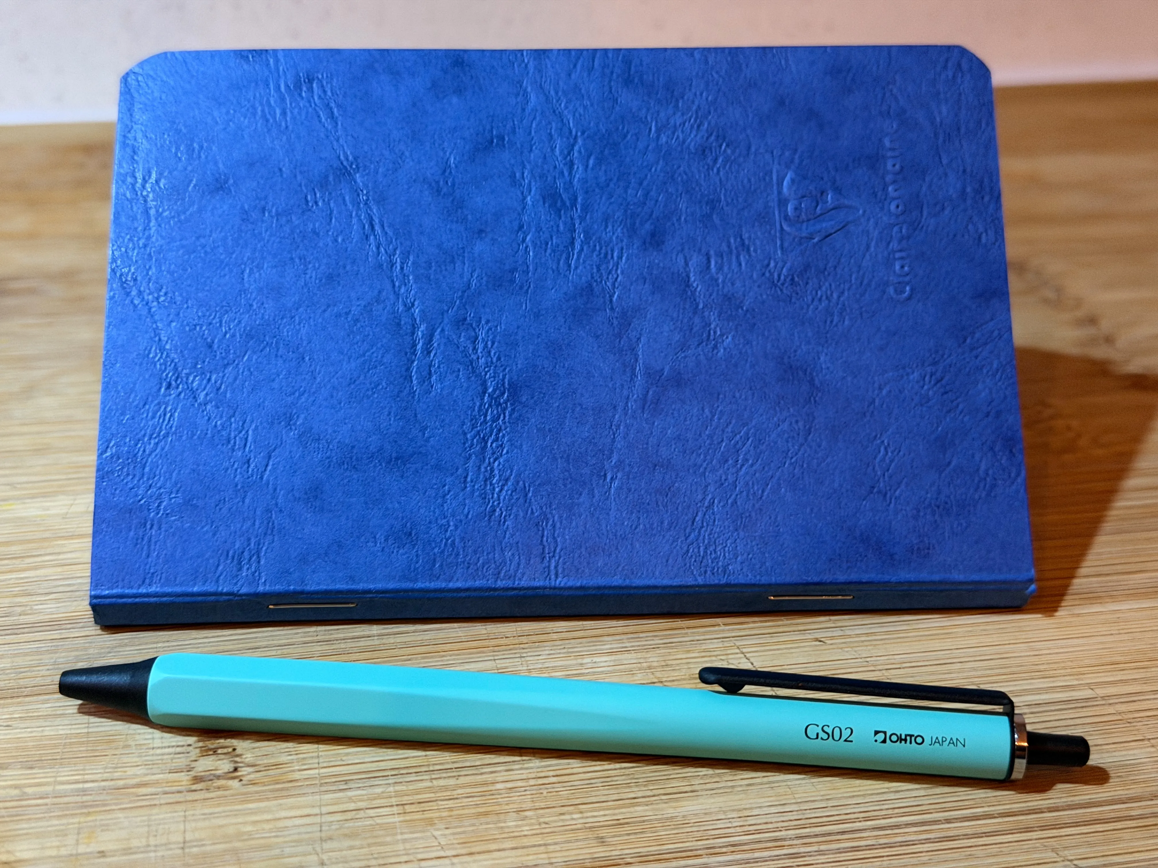 OHTO GS02 Mint Gel Pen next to a blue Clairefontaine notebook